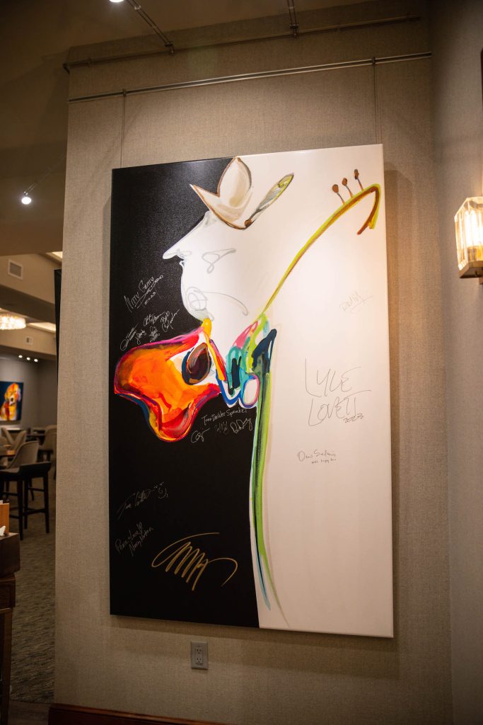 Artwork by Carrie Fell being signed by Vilar Center performers - Vimarsana News